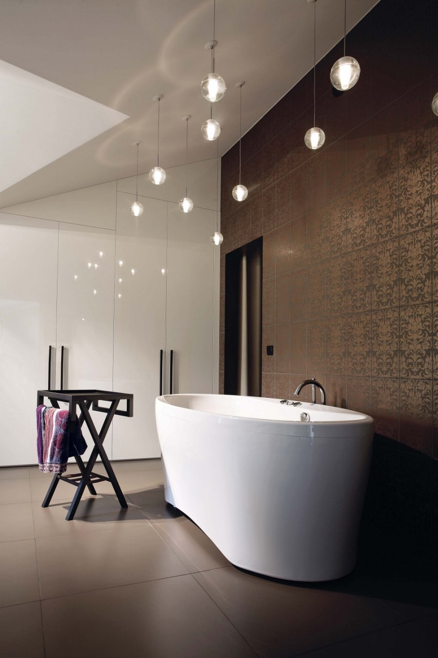 Modernaus dizaino vonios kambario interjerui puošnumo ir žaismingumo suteikia skirtingame aukštyje pakabinti permatomi šviečiantys burbulai, atrodantys tarsi vandens lašeliai.